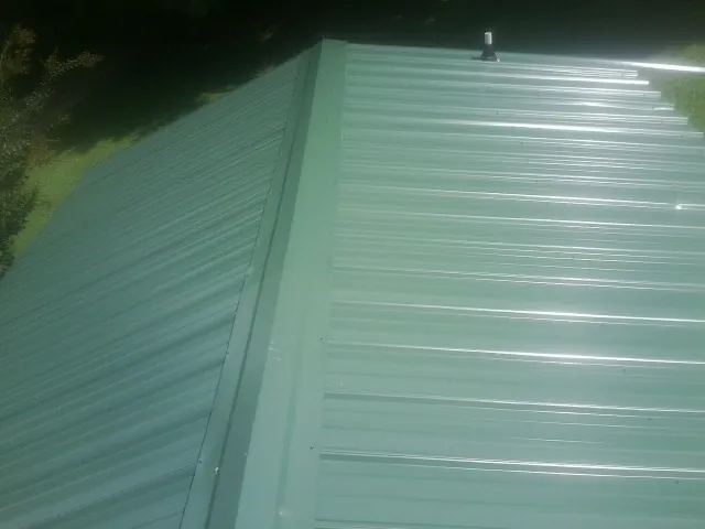 New green metal panels meeting at the ridge of a roof — Flat Roof Repair work by our crew in Palomar Mountain