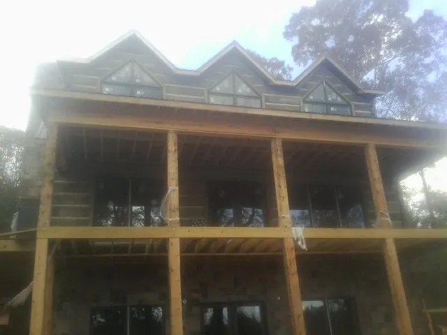 Dormers and porch framing on a large log home under construction — Roof Coating work by our crew in Palomar Mountain