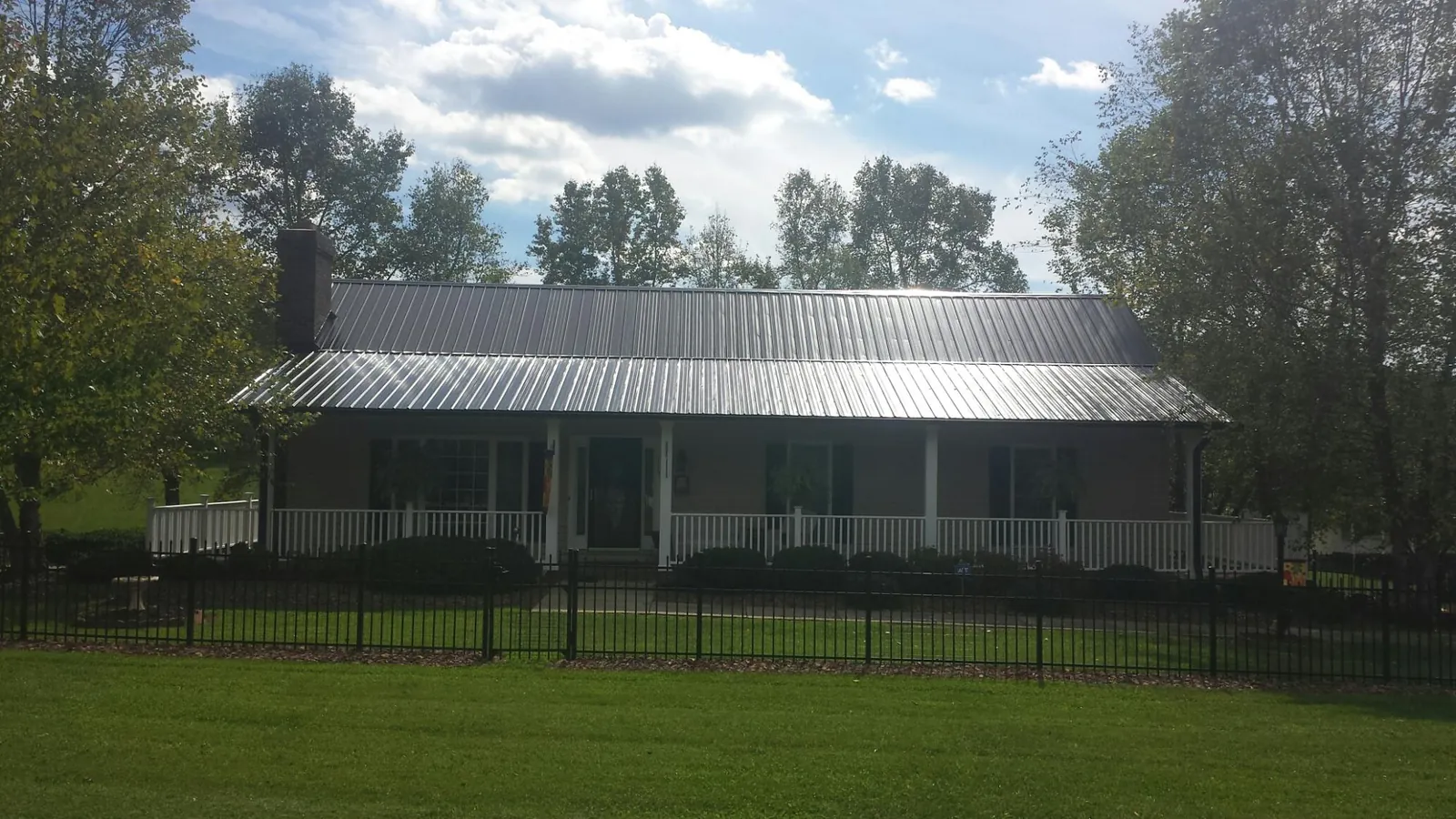 Gray metal roof on a brick ranch with a full width front porch — Gutter Guard Installation work by our crew in Palomar Mountain